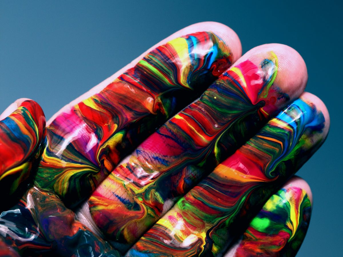 Hand voller bunter, ineinander verlaufender Farben