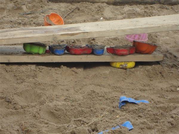 Sandförmchen auf einem Brett im Sandkasten